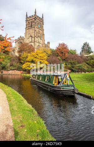 Narrowboat auf dem Staffordshire und Worcester Kanal bei der St. Mary's und All Saints Kirche in der Worcestershire Stadt Kidderminster im Herbst Stockfoto