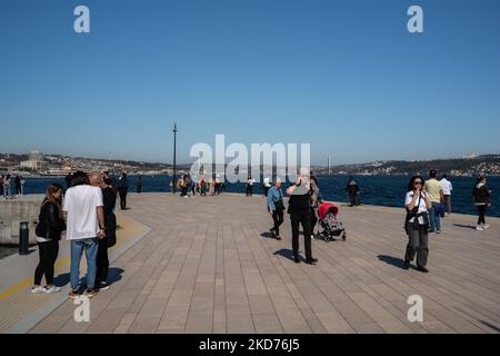 Am 9. April 2022 in Istanbul, Türkei, laufen die Menschen am Galataport weiter und beobachten den Bosporus. Galataport liegt im Istanbuler Stadtteil Karakoy und wurde als moderner Hafen für große Kreuzschiffe konzipiert. Die restaurierten historischen Gebäude dienen heute als Restaurants, Bekleidungsgeschäfte und Museen. (Foto von Erhan Demirtas/NurPhoto) Stockfoto