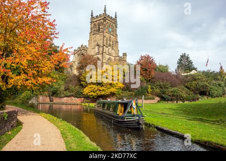 Narrowboat auf dem Staffordshire und Worcester Kanal bei der St. Mary's und All Saints Kirche in der Worcestershire Stadt Kidderminster im Herbst Stockfoto