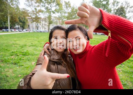 Asiatische Freunde genießen sich im öffentlichen Park, Zweisamkeit und Freundschaftskonzepte Stockfoto