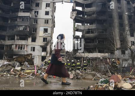 Die Frau kommt an einem von der russischen Armee zerstörten Wohnhaus in der Stadt Borodyanka in der Nähe von Kiew, Ukraine, vorbei, 09. April 2022 (Foto: Maxym Marusenko/NurPhoto) Stockfoto