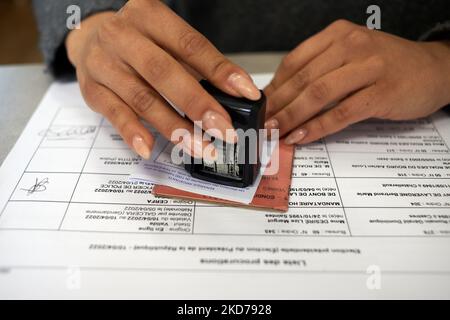 Ein Beurteiler stempelt eine Wahlkarte. Für die erste Runde der französischen Präsidentschaftswahlen gehen die Leute zum Wahllokal. Selbst wenn die Meinungsforscher sagten, dass die Enthaltung bei etwa 30 % liegen wird (ein Rekord bei den Präsidentschaftswahlen), gaben die Gutachter des Wahllokale an, dass mehr Menschen zur Stimmabgabe kamen als im Jahr 2017. Zwölf Kandidaten kandidieren für die Wahl, darunter Emmanuel Macron, der derzeit im Amt ist. Toulouse. Frankreich. April 10. 2022. (Foto von Alain Pitton/NurPhoto) Stockfoto