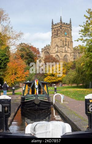 Narrowboat auf dem Staffordshire und Worcester Kanal bei der St. Mary's und All Saints Kirche in der Worcestershire Stadt Kidderminster im Herbst Stockfoto