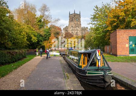 Narrowboat auf dem Staffordshire und Worcester Kanal bei der St. Mary's und All Saints Kirche in der Worcestershire Stadt Kidderminster im Herbst Stockfoto