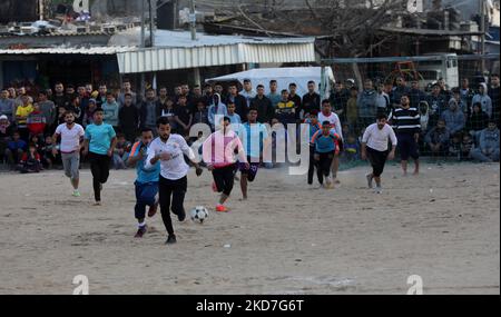 Palästinensische Jugendliche spielen in einem Flüchtlingslager in Rafah im südlichen Gazastreifen Fußball, bevor sie während des heiligen muslimischen Monats Ramadan am 12. April 2022 ihr Fasten brechen. - Während des ganzen Monats müssen fromme Muslime von der Morgendämmerung bis zum Sonnenuntergang auf Essen und Trinken verzichten, wenn sie das Fasten mit dem Iftar-Essen brechen. (Foto von Majdi Fathi/NurPhoto) Stockfoto