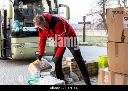 Freiwillige tragen Pakete, die von einem ehrenamtlichen Unternehmen - Abdar Travel Agency aus Krakau, Polen, geliefert werden, zu einem Haus, das am 12. April 2022 vorübergehend in ein Kinderheim der griechisch-katholischen Kirche in Nadyby, in der Nähe von Lviv, Ukraine, verlegt wurde. Seit dem Einmarsch der Russischen Föderation in die Ukraine zwang der Konflikt mehr als 10 Millionen Menschen zur Flucht aus ihren Häusern, sowohl intern als auch extern. Viele polnische NGOs und Einzelpersonen leisten Hilfe für die Vertriebenen. Das Reisebüro Abdar ist ein Unternehmen, das von der ukrainischen Olga und dem polnischen Maciej Oszal geleitet wird. Seit Beginn des Konflikts th Stockfoto