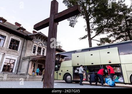 Freiwillige tragen Pakete, die von einem ehrenamtlichen Unternehmen - Abdar Travel Agency aus Krakau, Polen, geliefert werden, zu einem Haus, das am 12. April 2022 vorübergehend in ein Kinderheim der griechisch-katholischen Kirche in Nadyby, in der Nähe von Lviv, Ukraine, verlegt wurde. Seit dem Einmarsch der Russischen Föderation in die Ukraine zwang der Konflikt mehr als 10 Millionen Menschen zur Flucht aus ihren Häusern, sowohl intern als auch extern. Viele polnische NGOs und Einzelpersonen leisten Hilfe für die Vertriebenen. Das Reisebüro Abdar ist ein Unternehmen, das von der ukrainischen Olga und dem polnischen Maciej Oszal geleitet wird. Seit Beginn des Konflikts th Stockfoto