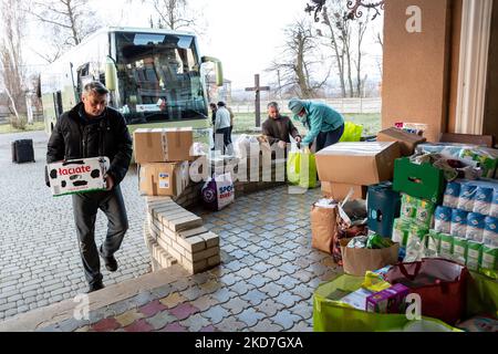 Freiwillige tragen Pakete, die von einem ehrenamtlichen Unternehmen - Abdar Travel Agency aus Krakau, Polen, geliefert werden, zu einem Haus, das am 12. April 2022 vorübergehend in ein Kinderheim der griechisch-katholischen Kirche in Nadyby, in der Nähe von Lviv, Ukraine, verlegt wurde. Seit dem Einmarsch der Russischen Föderation in die Ukraine zwang der Konflikt mehr als 10 Millionen Menschen zur Flucht aus ihren Häusern, sowohl intern als auch extern. Viele polnische NGOs und Einzelpersonen leisten Hilfe für die Vertriebenen. Das Reisebüro Abdar ist ein Unternehmen, das von der ukrainischen Olga und dem polnischen Maciej Oszal geleitet wird. Seit Beginn des Konflikts th Stockfoto