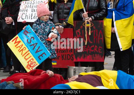 Die Menschen liegen am Boden und imitieren die Opfer des Krieges in ukrainischen Städten, in Toronto, Kanada, am 10. April 2022. Massengräber von mehr als 350 Zivilisten wurden nach der Niederlage der russischen Armee in den Kiewer Vororten Bucha, Irpin und Moschun gefunden (Foto: Anatolij Tscherkasow/NurPhoto) Stockfoto