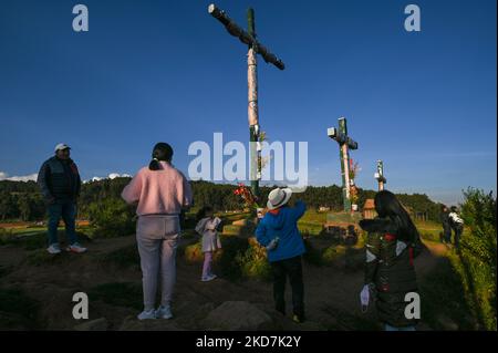 Mitglieder der Familie Manya auf dem Hügel mit den drei Kreuzen in Cusco, neben Cristo Blanco, einer großen Statue von Jesus Christus, gesehen. Der Gründonnerstag ist ein Tag frei für viele Einwohner von Cusco, die mit ihren Familien Orte besuchen, die mit der Tradition der Karwoche in Verbindung stehen. Am Donnerstag, den 14. April 2022, in Cusco, Peru. (Foto von Artur Widak/NurPhoto) Stockfoto