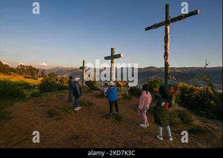 Mitglieder der Familie Manya auf dem Hügel mit den drei Kreuzen in Cusco, neben Cristo Blanco, einer großen Statue von Jesus Christus, gesehen. Der Gründonnerstag ist ein Tag frei für viele Einwohner von Cusco, die mit ihren Familien Orte besuchen, die mit der Tradition der Karwoche in Verbindung stehen. Am Donnerstag, den 14. April 2022, in Cusco, Peru. (Foto von Artur Widak/NurPhoto) Stockfoto