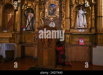 Ein Gläubiger während einer Beichte in der Basilika von La Merced. Alle Kirchen in Cusco sind am Gründonnerstag für die Öffentlichkeit ohne Eintrittsgebühren geöffnet. Die Tradition hat es, dass eine Person, die sieben Kirchen besucht, seinen Wunsch wird gewährt werden. Am Donnerstag, den 14. April 2022, in Cusco, Peru. (Foto von Artur Widak/NurPhoto) Stockfoto