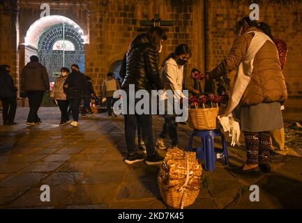 Eine Einheimische verkauft vor der Kirche San Francisco de Asís Zuckeräpfel. Alle Kirchen in Cusco sind am Gründonnerstag für die Öffentlichkeit ohne Eintrittsgebühren geöffnet. Die Tradition hat es, dass eine Person, die sieben Kirchen besucht, seinen Wunsch wird gewährt werden. Am Donnerstag, den 14. April 2022, in Cusco, Peru. (Foto von Artur Widak/NurPhoto) Stockfoto