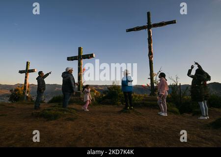 Mitglieder der Familie Manya auf dem Hügel mit den drei Kreuzen in Cusco, neben Cristo Blanco, einer großen Statue von Jesus Christus, gesehen. Der Gründonnerstag ist ein Tag frei für viele Einwohner von Cusco, die mit ihren Familien Orte besuchen, die mit der Tradition der Karwoche in Verbindung stehen. Am Donnerstag, den 14. April 2022, in Cusco, Peru. (Foto von Artur Widak/NurPhoto) Stockfoto