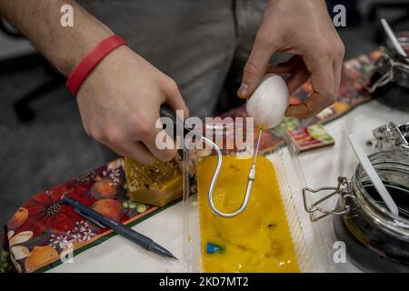 Ein Ei wird mit einem speziellen Werkzeug, das Luft durch ein kleines Loch im Ei pumpt, vor dem ukrainischen Osterfest während eines Workshops zur Herstellung von Pysanka an der Nordostuniversität entleert. Die Entwürfe werden mit Wachs gezeichnet und die Eier werden in Schichten gefärbt, beginnend mit der hellsten Farbe bis hin zu rot oder schwarz. Am Ende wird das Wachs entfernt, um ein aufwendig dekoriertes Ei zu offenbaren. (Foto von Jodi Hilton/NurPhoto) Stockfoto