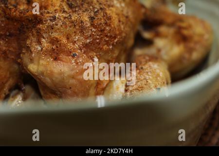 Hausgemachte gewürzte und gekochte ganze gebratene Hähnchen in einem Tablett. Makro-Nahaufnahme von köstlich gekochten, gesunden Hähnchen. Konzept für gesundes Kochen Stockfoto