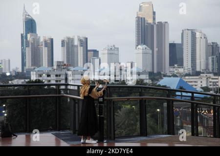 Am 18. April 2022 genießen die Menschen die Landschaften von Jakarta von der Senayan Skywalk-Brücke in Jakarta. (Foto von Aditya Irawan/NurPhoto) Stockfoto