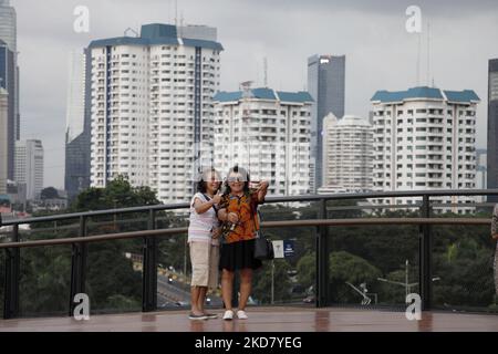 Am 18. April 2022 genießen die Menschen die Landschaften von Jakarta von der Senayan Skywalk-Brücke in Jakarta. (Foto von Aditya Irawan/NurPhoto) Stockfoto