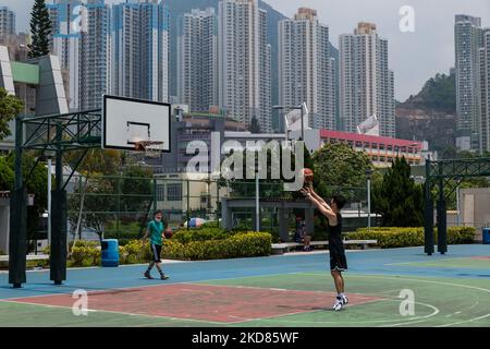 Ein junger Mann spielt Basketball auf einem Gelände, das kürzlich in Kowloon Bay wiedereröffnet wurde. (Foto von Marc Fernandes/NurPhoto) Stockfoto