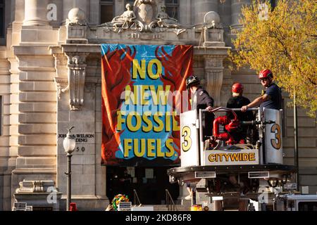 Ein Mitglied der Extinction Rebellion wird von DC Fire entfernt, nachdem ein Banner aus der zweiten Etage des John Wilson-Gebäudes, in dem sich die Stadtbüros von Washington, DC befinden, abgetragen wurde. Zum Earth Day veranstaltete die Gruppe eine Kundgebung und einen marsch, um gegen fossile Brennstoffe im Allgemeinen zu protestieren und speziell zu fordern, dass die Stadt sich weigert, Washington Gas den Ausbau seiner Methanlieferungsinfrastruktur zu gestatten. Sie wurde von der DC Feuerwehr entfernt und sofort von der DC Polizei verhaftet. Extinction Rebellion lehnte es ab, ihren Namen anzugeben. (Foto von Allison Bailey/NurPhoto) Stockfoto