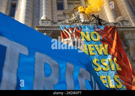 Ein Demonstrator mit dem Aussterben Rebellion DC winkt Rauchmelder, nachdem er das John A. Wilson-Gebäude erklimmen und am 22. April 2022 in Washington, D.C. ein Banner gegen die Praktiken von Washington Gas entrollt hat (Foto: Bryan Olin Dozier/NurPhoto) Stockfoto