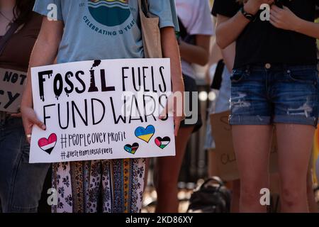 Ein Demonstrator zeigt ein Schild, das fossile Brennstoffe freitags mit Kriegen rund um den Globus für den zukünftigen Klimaangriff am Erdtag verbindet. Die Demonstranten forderten, dass die Regierung Biden die Investitionen in und den Bau der Infrastruktur für fossile Brennstoffe einstellt und stattdessen diese Ressourcen in erneuerbare Energien investiert. (Foto von Allison Bailey/NurPhoto) Stockfoto