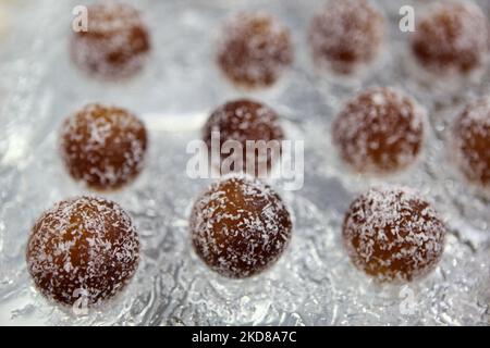 Gulab Jamuns garniert mit Kokosflocken, die auf einem Tisch aus Eis bei einer indischen Hochzeit in Toronto, Ontario, Kanada, liegen. Der Gulab jamun ist ein beliebtes indisches Süßes, das oft auf Festen oder großen Feiern wie Hochzeiten, Diwali (das indische Fest des Lichts) und den muslimischen Feiern von Eid ul-Fitr und Eid al-Adha gegessen wird. Es gibt verschiedene Arten von Gulab Jamun und jede Sorte hat einen eigenen Geschmack und Aussehen. (Foto von Creative Touch Imaging Ltd./NurPhoto) Stockfoto