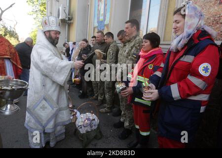 Ein ukrainischer Priester segnet Gläubige während der orthodoxen Osterzeit, während der russischen Invasion in der Ukraine, in der Kathedrale der Geburt Christi der orthodoxen Kirche der Ukraine in Odesa, Ukraine, 24. April 2022 mit Körben mit Osterkuchen und bemalten Eiern. Orthodoxe Christen feiern Ostern am 24.. April. (Foto von STR/NurPhoto) Stockfoto