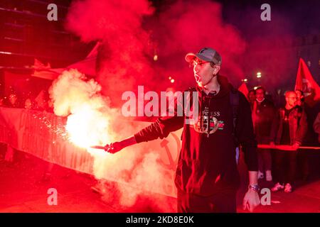 Ein Protestler hält eine rote Rauchbombe-Fahne der Partei), um gegen die Beteiligung der italienischen Regierung an der ukrainischen Krise zu protestieren. Nach der Pause aufgrund von Zwangsbeschränkungen kehrt am 24. April 2022 der traditionelle Fackelzug zum Jahrestag der Befreiung in Turin, Italien, zurück. Der Jahrestag der Befreiung Italiens ist ein Feiertag, der jedes Jahr in Italien begangen wird, um dem Ende der Nazi-Besatzung des Landes und dem Zusammenbruch des faschistischen Regimes zu gedenken. (Foto von Mauro Ujetto/NurPhoto) Stockfoto