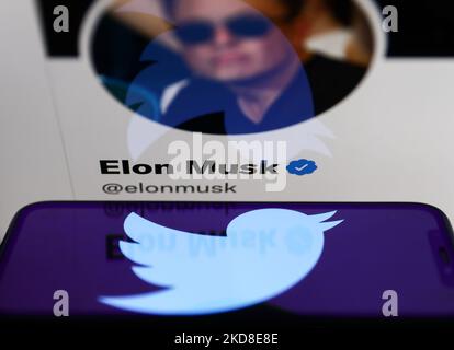 Das Twitter-Logo, das auf einem Telefonbildschirm angezeigt wird, und Elon Musks Twitter-Account auf einem Laptop-Bildschirm sind auf dieser Illustration zu sehen, die am 26. April 2022 in Krakau, Polen, aufgenommen wurde. (Foto-Illustration von Jakub Porzycki/NurPhoto) Stockfoto