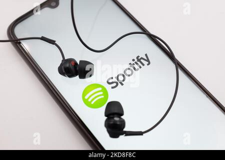 In dieser Abbildung wird das Spotify-Logo am 26. April 2022 auf einem Smartphone-Bildschirm mit Kopfhörern in Chania, Kreta, Griechenland, angezeigt. (Fotoillustration von Nikolas Kokovlis/NurPhoto) Stockfoto