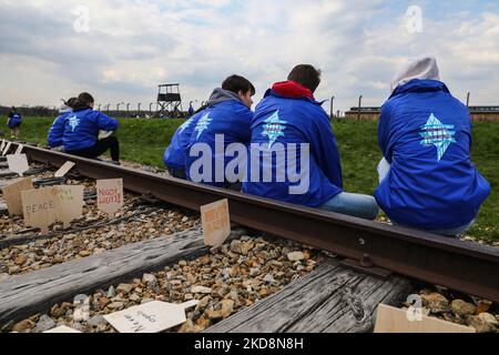 Die Teilnehmer werden am 28. April 2022 während des „Marsches der Lebenden“ im ehemaligen KZ-Vernichtungslager Auschwitz-Birkenau in Brzezinka, Polen, gesehen. Der jährliche märz ist Teil eines Bildungsprogramms, das jüdische Studenten aus der ganzen Welt nach Polen bringt, wo sie die Überreste des Holocaust erkunden. Die Teilnehmer marschieren lautlos drei Kilometer von Auschwitz I nach Auschwitz II Birkenau, dem größten NS-Konzentrationslager-Komplex, der während des Zweiten Weltkriegs erbaut wurde (Foto von Beata Zawrzel/NurPhoto) Stockfoto