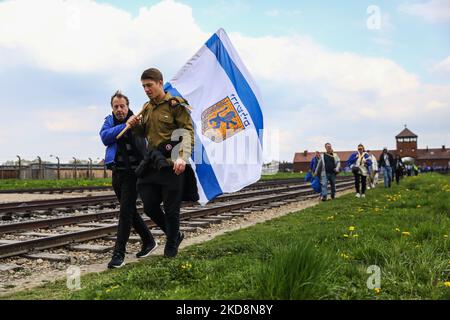 Die Teilnehmer werden am 28. April 2022 während des „Marsches der Lebenden“ im ehemaligen KZ-Vernichtungslager Auschwitz-Birkenau in Brzezinka, Polen, gesehen. Der jährliche märz ist Teil eines Bildungsprogramms, das jüdische Studenten aus der ganzen Welt nach Polen bringt, wo sie die Überreste des Holocaust erkunden. Die Teilnehmer marschieren lautlos drei Kilometer von Auschwitz I nach Auschwitz II Birkenau, dem größten NS-Konzentrationslager-Komplex, der während des Zweiten Weltkriegs erbaut wurde (Foto von Beata Zawrzel/NurPhoto) Stockfoto