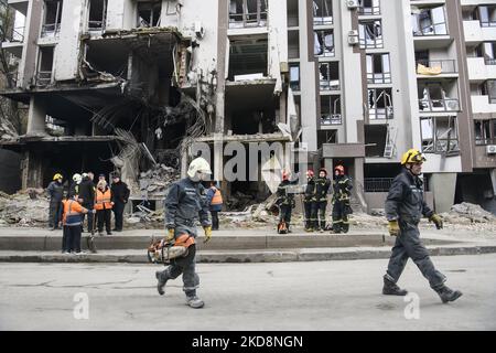 Retter gehen in Kiew, Ukraine, nahe an einen Wohnblock, der während der russischen Invasion in der Ukraine bei einem Raketenbeschuss zerstört wurde 29. April 2022 (Foto: Maxym Marusenko/NurPhoto) Stockfoto