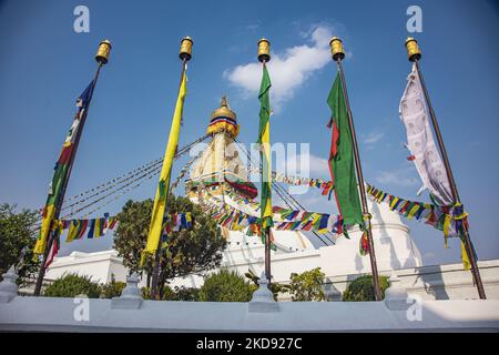 Nahaufnahme an der goldenen Spitze mit den Augen der Stupa, wo die Gebetsfahnen beginnen. Boudhanath oder Bouddha Stupa in Kathmandu ein UNESCO-Weltkulturerbe und ein legendärer Ort für die newarische und tibetisch-buddhistische Mythologie mit dem goldenen Teil, der die Augen von Boudhanath und die Gebetsfahnen hat. Das Mandala, eine der beliebtesten Touristenattraktionen in Kathmandu, macht es zu einem der größten kugelförmigen Stupas in Nepal und der Welt. Die Stupa wurde beim Erdbeben vom 2015. April beschädigt. Die Stupa befindet sich auf der alten Handelsstraße von Tibet, und die tibetischen Flüchtlinge nach dem 1950s beschlossen, Li Stockfoto