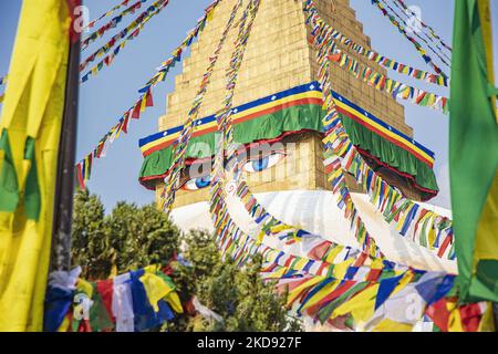 Nahaufnahme an der goldenen Spitze mit den Augen der Stupa, wo die Gebetsfahnen beginnen. Boudhanath oder Bouddha Stupa in Kathmandu ein UNESCO-Weltkulturerbe und ein legendärer Ort für die newarische und tibetisch-buddhistische Mythologie mit dem goldenen Teil, der die Augen von Boudhanath und die Gebetsfahnen hat. Das Mandala, eine der beliebtesten Touristenattraktionen in Kathmandu, macht es zu einem der größten kugelförmigen Stupas in Nepal und der Welt. Die Stupa wurde beim Erdbeben vom 2015. April beschädigt. Die Stupa befindet sich auf der alten Handelsstraße von Tibet, und die tibetischen Flüchtlinge nach dem 1950s beschlossen, Li Stockfoto