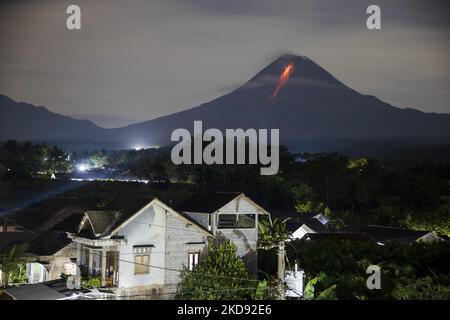 Der Berg Merapi, ein vulkanischer Berg, spuckt Lava aus, während er mehrere Male ausbricht, wie er am 29. Dezember 2021 aus dem Dorf Kaliurang in Magelang, Zentraljava, Indonesien, gesehen wurde. Merapi liegt in einem der am dichtesten besiedelten Teile von Java mit über 11.000 Menschen, die an den Hängen des Berges leben. Die meisten dieser Menschen sind Bauern, die für ihren Lebensunterhalt vom Reichtum des Bodens abhängig sind. (Foto von Garry Lotulung/NurPhoto) Stockfoto