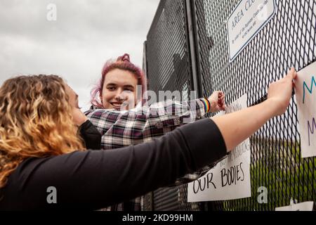 Die College-Studenten Julia Waldon (oben) und Lauren Wynne hängen nach einer Wahlkampfveranstaltung vor dem Obersten Gerichtshof ihre Schilder auf dem neu installierten, 8 Meter langen „nicht skalierbaren“ Zaun auf. Diese Art von Einzäunung wurde verwendet, um Demonstranten sowohl aus dem Weißen Haus (George Floyd) als auch aus dem Kapitol (Aufstand vom 6. Januar) zu blockieren und steht nun um den Obersten Gerichtshof herum. Die Kundgebung war eine von vielen, da ein Leitentwurf in Dobbs v. JWHO enthüllte, dass die Richter dafür stimmten, Roe v. Wade zu stürzen und das Bundesrecht auf Abtreibungszugang aufzuheben. (Foto von Allison Bailey/NurPhoto) Stockfoto