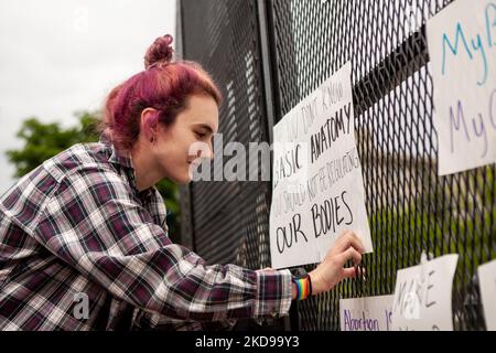 Julia Waldon hängt nach einer Wahlkampfveranstaltung vor dem Obersten Gerichtshof ein Schild am neu installierten, 8 Meter langen „nicht skalierbaren“ Zaun. Diese Art von Einzäunung wurde verwendet, um Demonstranten sowohl aus dem Weißen Haus (George Floyd) als auch aus dem Kapitol (Aufstand vom 6. Januar) zu blockieren und steht nun um den Obersten Gerichtshof herum. Die Kundgebung war eine von vielen, da ein in Dobbs v. JWHO durchgesickerte Stellungnahmeentwurf enthüllte, dass die Richter dafür stimmten, Roe v. Wade zu stürzen und das bundesstaatliche Recht auf Abtreibungszugang aufzuheben. (Foto von Allison Bailey/NurPhoto) Stockfoto