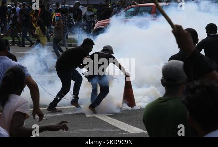 Studenten der Universität Sri Lankas schütten einen Tränengaskanister aus, indem sie Wasser durch einen Verkehrskegel gießen, während sie am 6. Mai 2022 in der Nähe des parlaments in Colombo, Sri Lanka, den sofortigen Rücktritt von Präsident Gotabaya Rajapaksa und der Regierung forderten. Der Präsident Sri Lankas erklärte zum zweiten Mal in fünf Wochen den Ausnahmezustand und gab den Sicherheitskräften weitreichende Befugnisse, als ein landesweiter Streik wütender Demonstranten das Land lahmlegte. (Foto von Tharaka Basnayaka/NurPhoto) Stockfoto