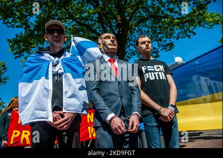 Ein Mann, der als russischer Präsident Wladimir Putin gekleidet ist, wird während eines symbolischen Prozesses gegen ihn am 8.. Mai 2022 in Den Haag mit Handschellen gefesselt. (Foto von Romy Arroyo Fernandez/NurPhoto) Stockfoto
