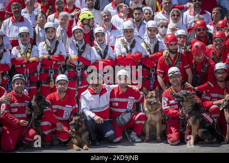 Mitglieder der Iranischen Rothalbmond-Gesellschaft und Such- und Rettungshunde posieren für ein Foto nach einer Zeremonie anlässlich des 100.. Jahrestages der Gründung der Organisation im Süden Teherans am 9. Mai 2022. (Foto von Morteza Nikoubazl/NurPhoto) Stockfoto