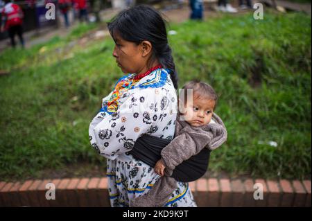 Eine indigene Mutter trägt ihr Baby auf dem Rücken, als die indigenen Gemeinden der Embera das provisorische Lager verlassen, das vor 8 Monaten errichtet wurde, wo mehr als 1000 durch Konflikte vertriebene indigene Menschen lebten und Vereinbarungen mit der Regierung getroffen haben, an einen nahe gelegenen Ort zu überführen, bevor sie in ihre Territorien zurückkehren. In Bogota, Kolumbien, 9. Mai 2022. (Foto von Sebastian Barros/NurPhoto) Stockfoto