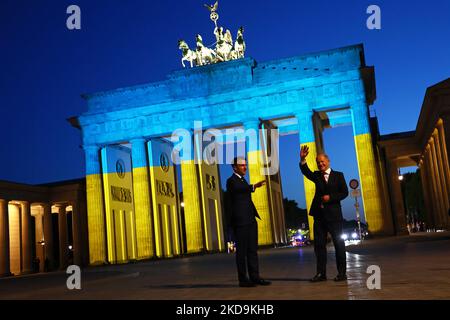 Der französische Präsident Emmanuel Macron (L) und Bundeskanzler Olaf Scholz besuchen am 9. Mai 2022 das mit der ukrainischen Flagge erleuchtete Brandenburger Tor in Berlin. (Foto von Emmanuele Contini/NurPhoto) Stockfoto