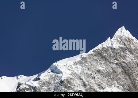 Langtang Lirung Peak aus Sicht des Dorfes Langtang, Teil des Langtang Himal Berges in Nepal mit dem höchsten Punkt in einer Höhe von 7234m oder 23734 Fuß. Der Langtang Lirung ist der 99. höchste Berg der Welt und wurde 1978 zum ersten Mal erreicht. Am 25. April 2015 führte ein massives Erdbeben der Stärke 7,8 zu einer Lawine und einem Erdrutsch im Dorf Langtang, bei dem direkt 243 Menschen getötet und das Dorf verschwungen wurden. Der Langtang National Park ist ein beliebtes Trekking- und Reiseland für ausländische Wanderer und Einheimische. Die Bewohner des Dorfes sind Tamang-Tibeter mit Ursprung in T Stockfoto