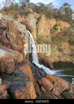 Eine vertikale Aufnahme des Wasserfalls der Nigretta Falls, der in Bulart, Australien, an steilen Klippen herabfließt Stockfoto