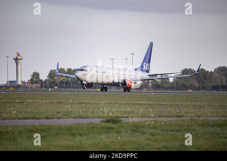 SAS Scandinavian Airlines Boeing 737-800-Flugzeuge während des Rollens, der Rotation, des Start- und der Flugphase beim Abflug von Amsterdam Schiphol AMS EHAM. Das B738-Personen-Düsenflugzeug fährt vor einem Kontrollturm, während es von der Start-und Landebahn Polderbaan abfliegt, das Flugzeug hat die Registrierung LN-RRH und den Namen Freja Viking. SAS ist die Flaggschiff-Fluggesellschaft Dänemarks, Norwegens und Schwedens, die Fluggesellschaft hat eine Flottengröße von 180 Flugzeugen und ist Mitglied der Star Alliance Aviation Group. Nach Angaben der europäischen Medien kündigte SAS 4000 Flugstreichungen in dieser Sommersaison aufgrund der st Stockfoto