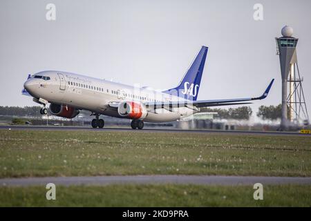 SAS Scandinavian Airlines Boeing 737-800-Flugzeuge während des Rollens, der Rotation, des Start- und der Flugphase beim Abflug von Amsterdam Schiphol AMS EHAM. Das B738-Personen-Düsenflugzeug fährt vor einem Kontrollturm, während es von der Start-und Landebahn Polderbaan abfliegt, das Flugzeug hat die Registrierung LN-RRH und den Namen Freja Viking. SAS ist die Flaggschiff-Fluggesellschaft Dänemarks, Norwegens und Schwedens, die Fluggesellschaft hat eine Flottengröße von 180 Flugzeugen und ist Mitglied der Star Alliance Aviation Group. Nach Angaben der europäischen Medien kündigte SAS 4000 Flugstreichungen in dieser Sommersaison aufgrund der st Stockfoto