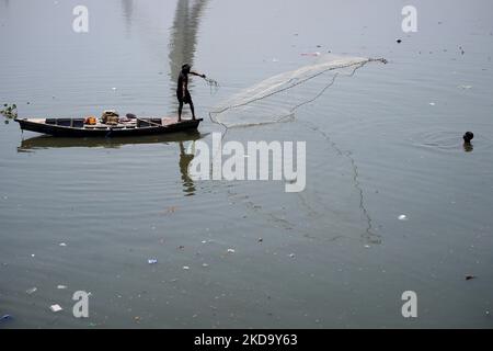 Ein einheimischer Fischer wirft sein Netz an einem heißen Sommertag in Neu-Delhi, Indien, am 14. Mai 2022 in das verschmutzte Wasser des Yamuna-Flusses. Der „Weltklimatag“ wird jedes Jahr am 15. Mai begangen, um auf eine Vielzahl von Umweltbelangen, insbesondere den globalen Klimawandel, aufmerksam zu machen. (Foto von Mayank Makhija/NurPhoto) Stockfoto