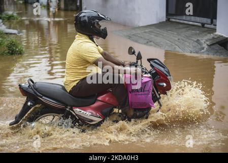 Pendler machen sich am 14. Mai 2022 nach heftigen Regenfällen in Guwahati, Assam, Indien, auf eine Wasserstraße auf den Weg. (Foto von David Talukdar/NurPhoto) Stockfoto